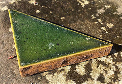 
A green glazed triangular tile from J C Edwards, Ruabon, Denbighshire  © Photo courtesy of Ian Evans